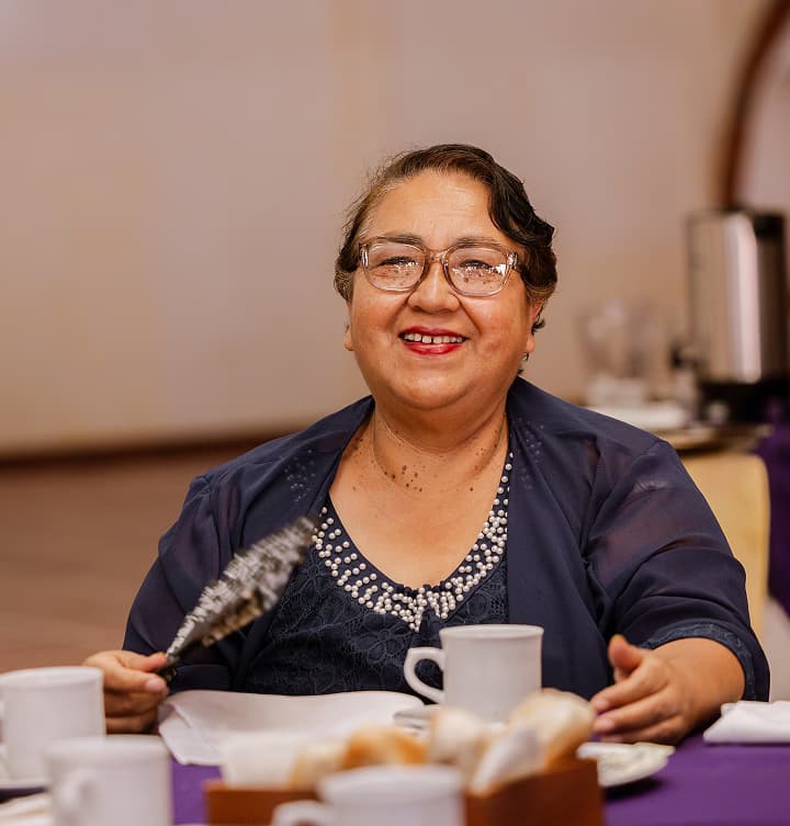 Happy woman having breakfast looking at the camera